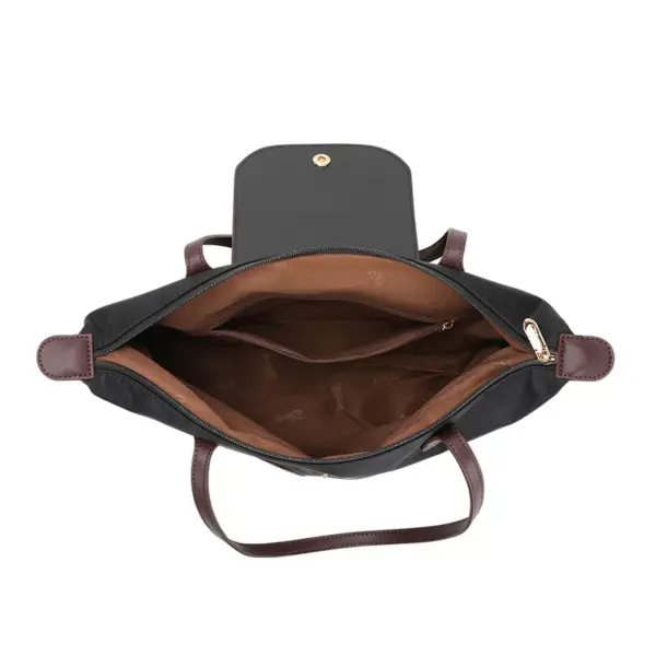 Interior of black nylon shoulder bag showing brown lining, zippered pocket, and spacious main compartment.