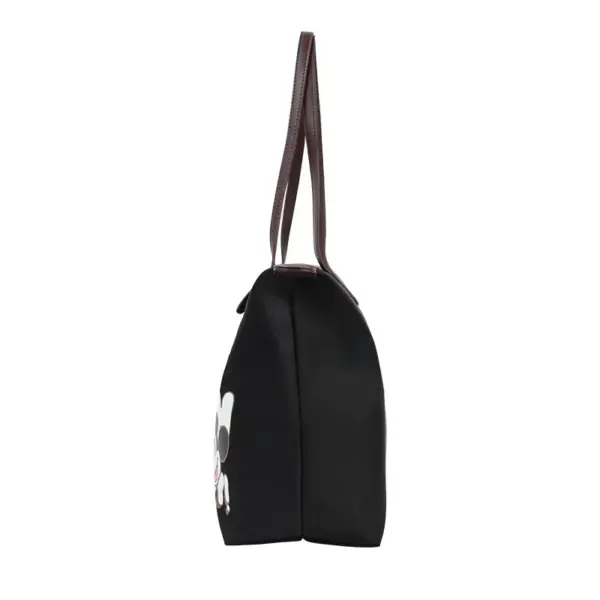 Side profile of a lightweight black nylon handbag with brown straps, showing depth and structure.