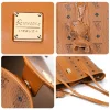 Close-ups of cognac Tokidoki tote: gold logo plaque, unicorn charm, magnetic snap and reinforced shoulder straps.