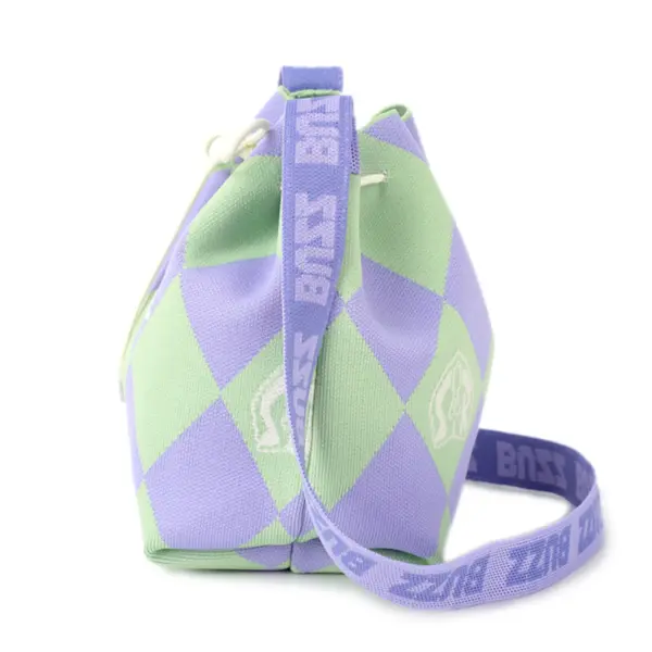 Side view of a purple and green argyle knit bucket bag with a woven "BUZZ" strap and drawstring closure.