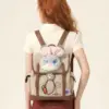 A woman wearing a Zootopia themed mini backpack with bunny ears and patches, showcasing the preppy academia style.