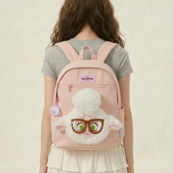 A young woman wearing a pastel pink padded school bag with a prominent 3D fluffy sheep face applique, big glasses, and zippered front pocket.