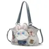 Side angle highlighting the fluffy bunny ears protruding from the top of the grey handbag, along with detailed embroidery patches.