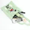 Flat lay showing a light green woven tote bag holding a tablet, phone, umbrella, perfume, and makeup essentials.