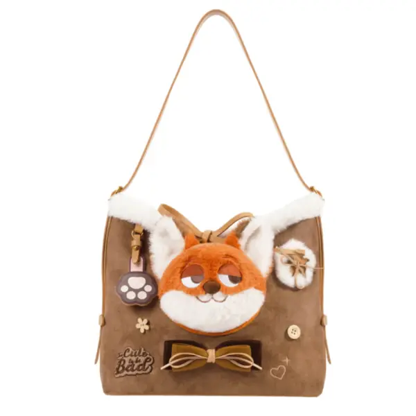 Flat lay product shot of a chocolate brown hobo bag with a large 3D orange fox face, bow tie accent, and cloud trim.