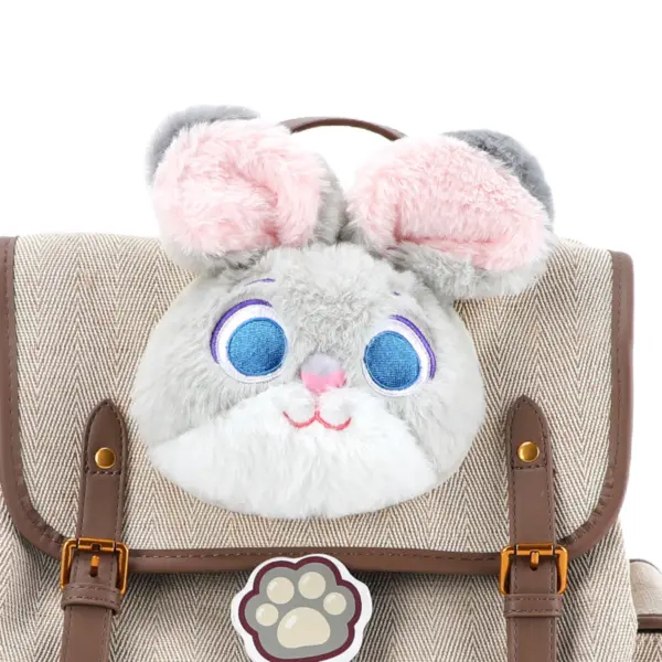 Extreme close-up of the soft grey and pink faux fur Judy Hopps ears and blue eyes applique on the backpack flap.