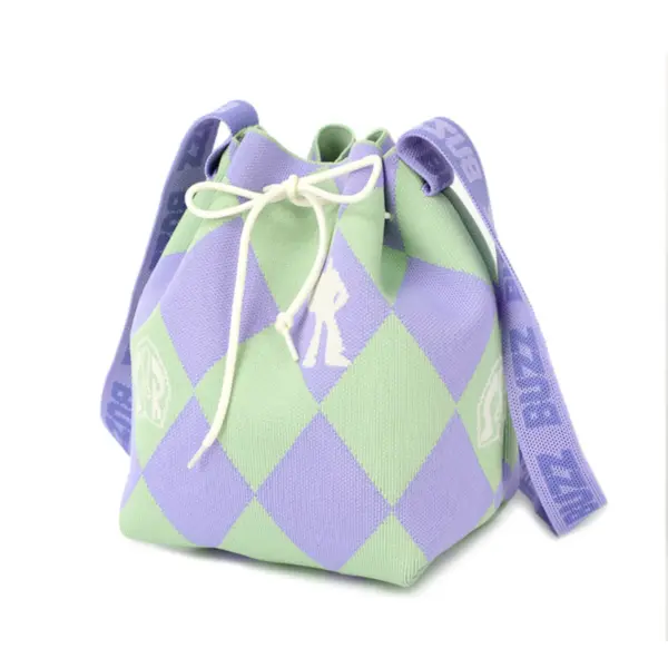 Angled view of a small knit drawstring purse with purple and green checks and a wide shoulder strap.