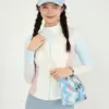 A woman wearing a blue Stitch knit crossbody bag with a wide shoulder strap, paired with sporty casual outfit.