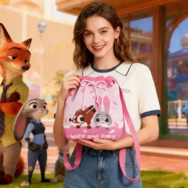 A smiling woman holding a pink Zootopia themed knit bucket bag with Nick and Judy design, outdoor theme park background.