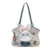 Front view of a grey suede-like shoulder bag featuring a plush Judy Hopps face, denim bow, and carrot charm accessory.